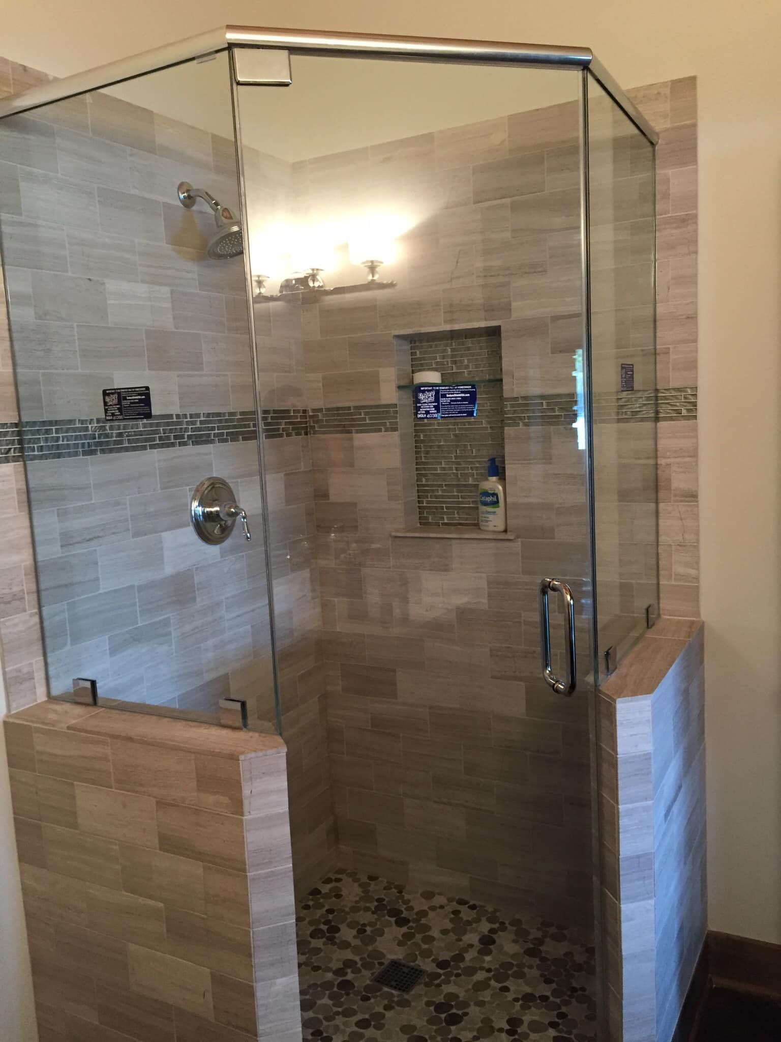 A bathroom with a walk in shower with a glass door