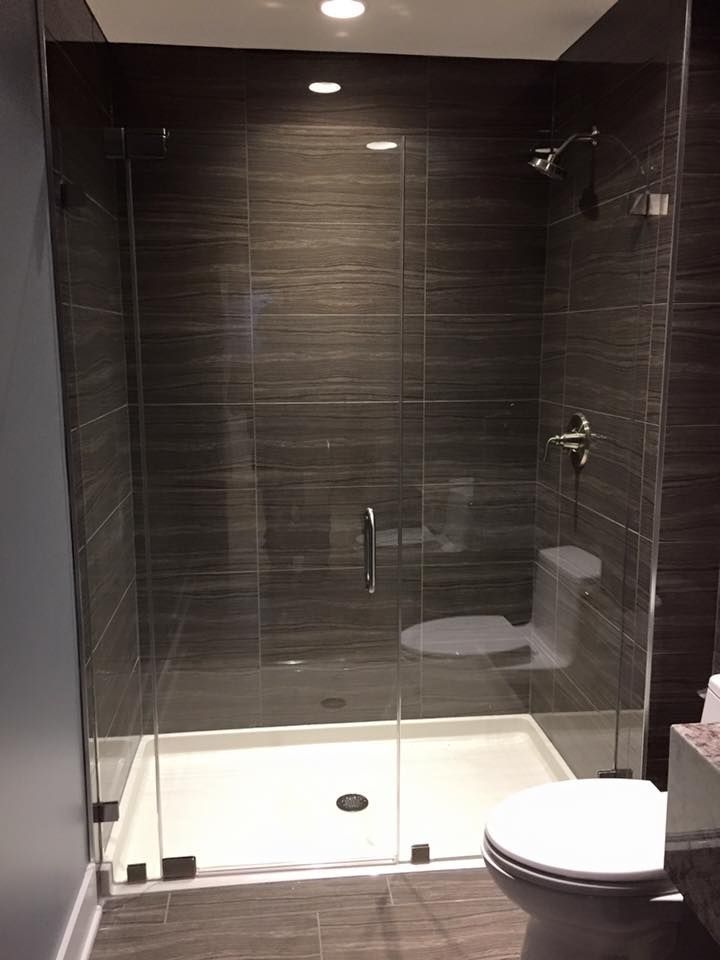 A bathroom with a toilet, shower, and glass door