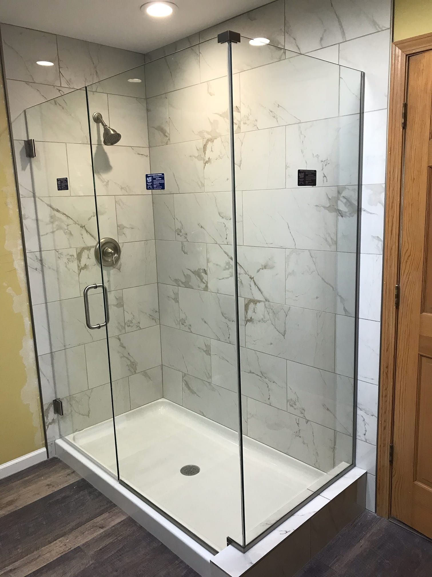 A bathroom with a walk in shower with a glass door
