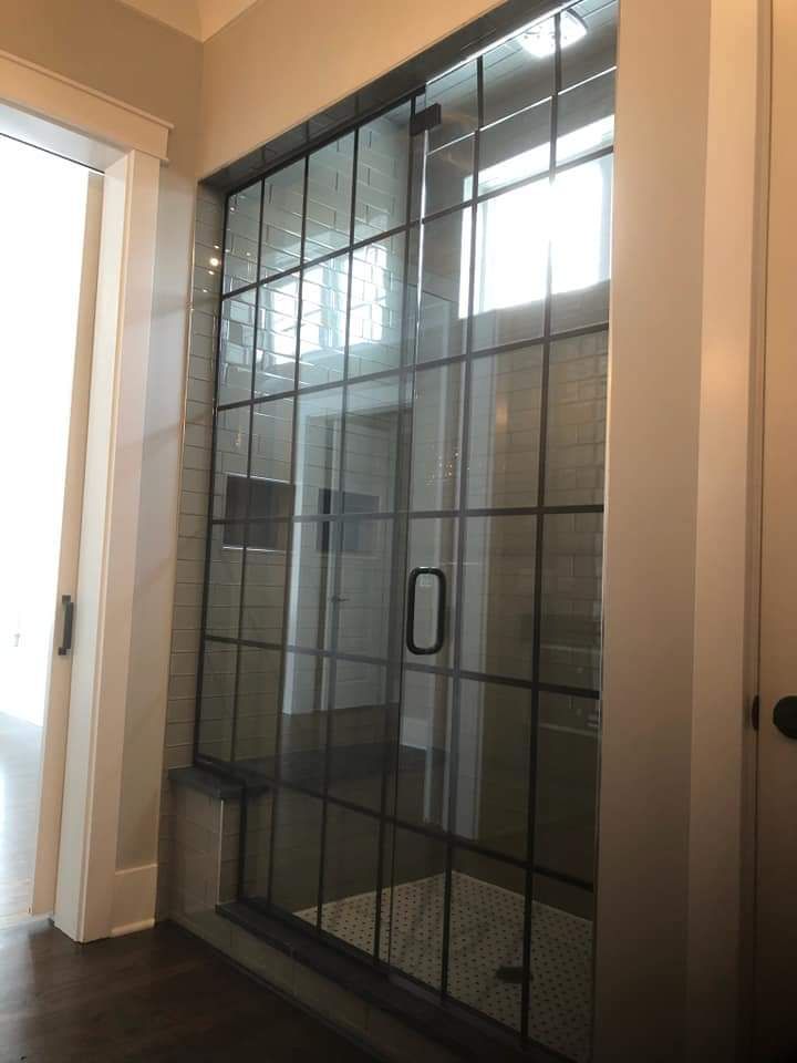 A bathroom with a sliding glass shower door