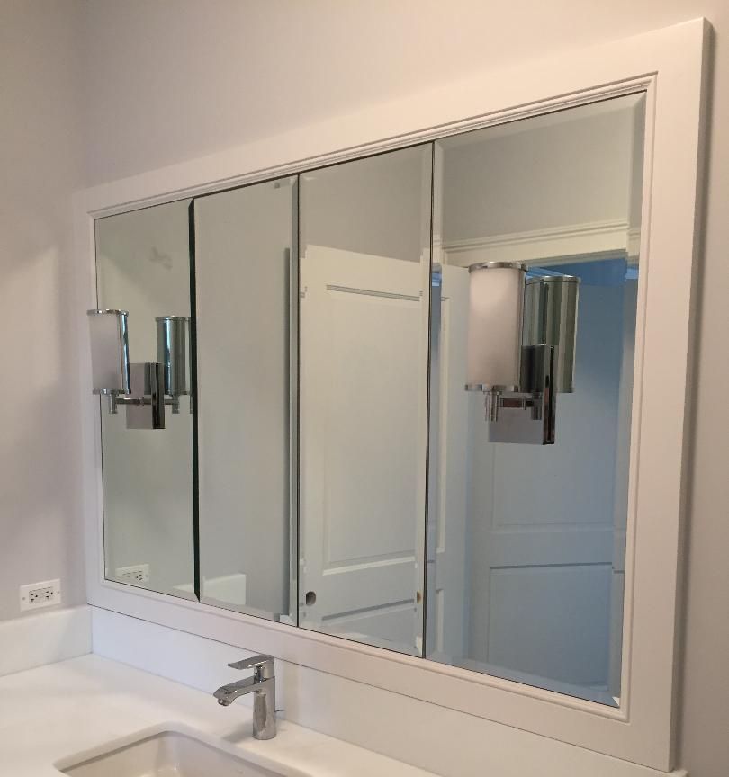 A bathroom with a large mirror and a sink