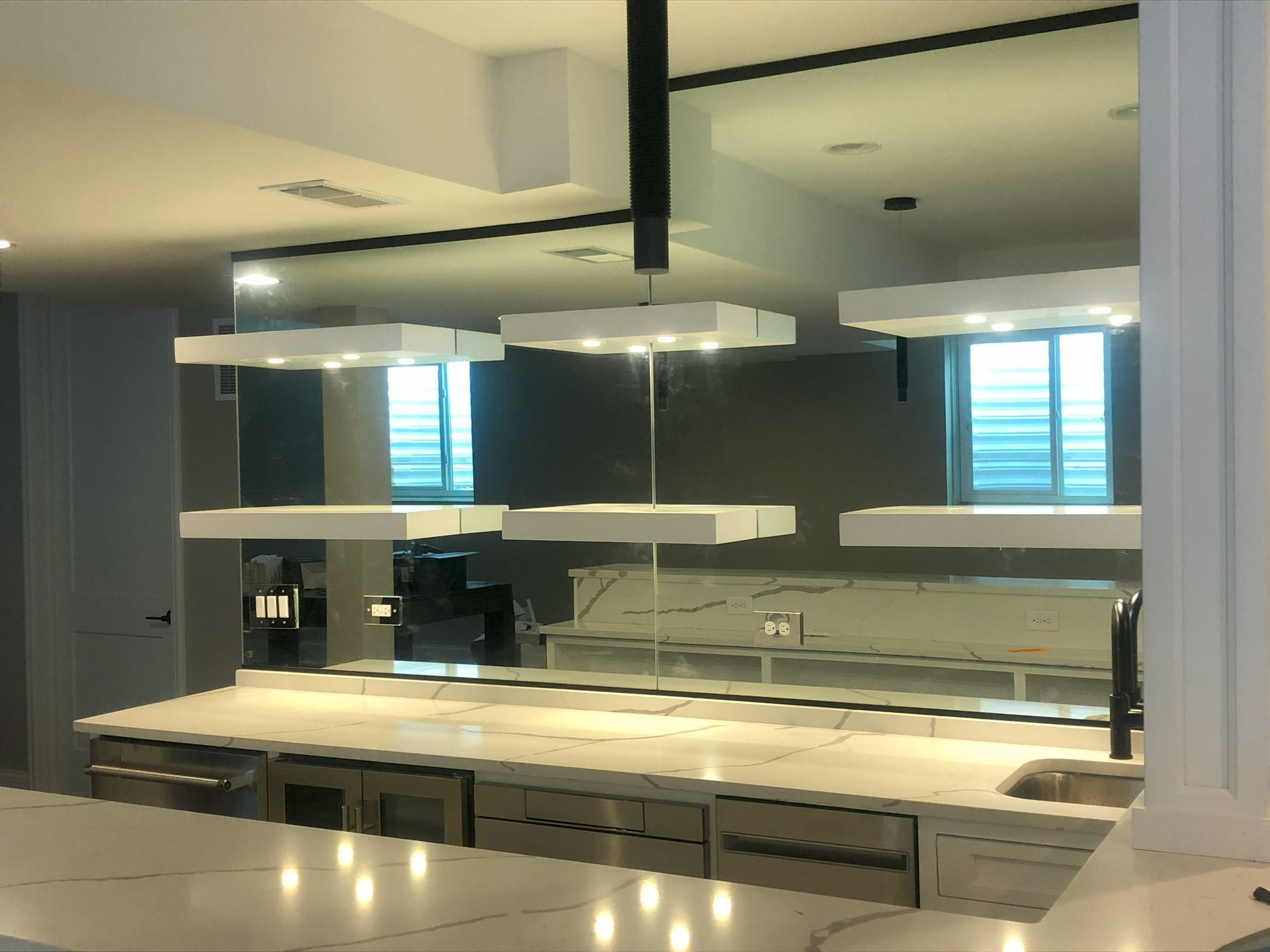 A kitchen with a large mirror backsplash