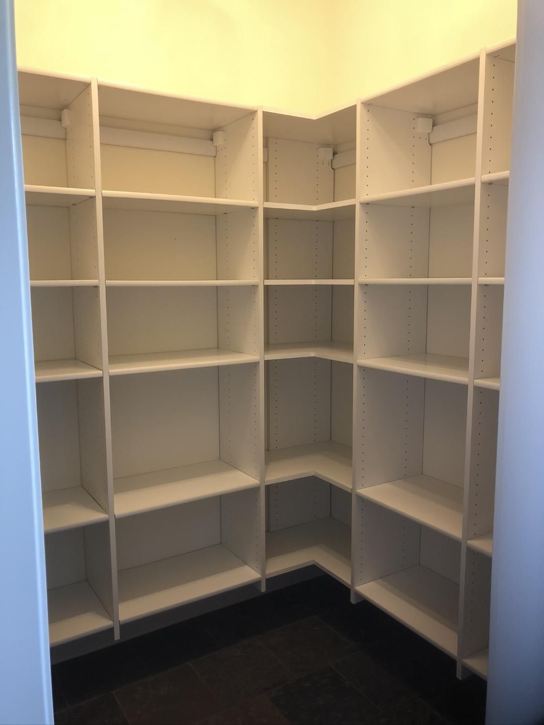 A closet with lots of shelves and a door