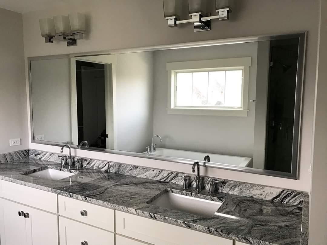 A bathroom with two sinks and a large mirror.