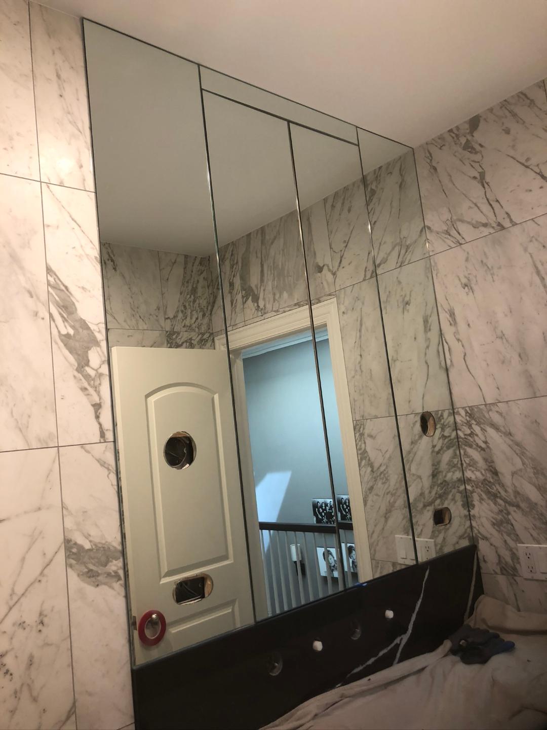 A bathroom with a large mirror on the wall.