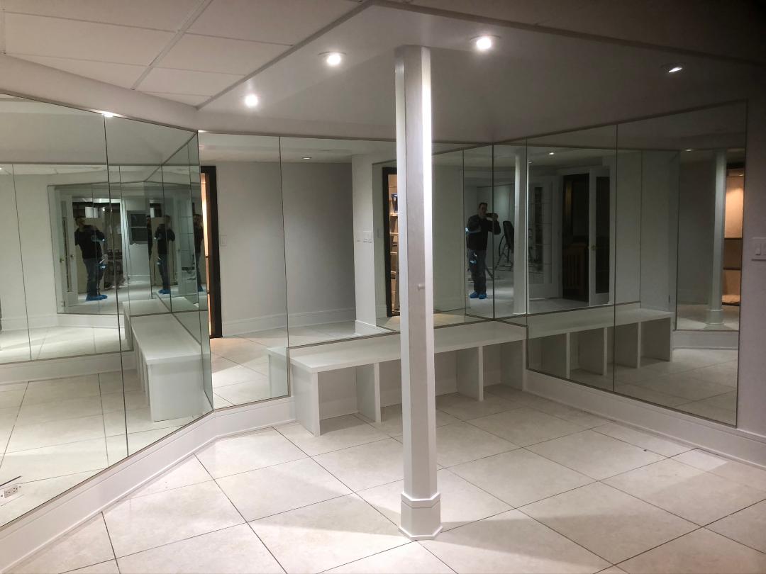 A room filled with lots of mirrors and a pillar.