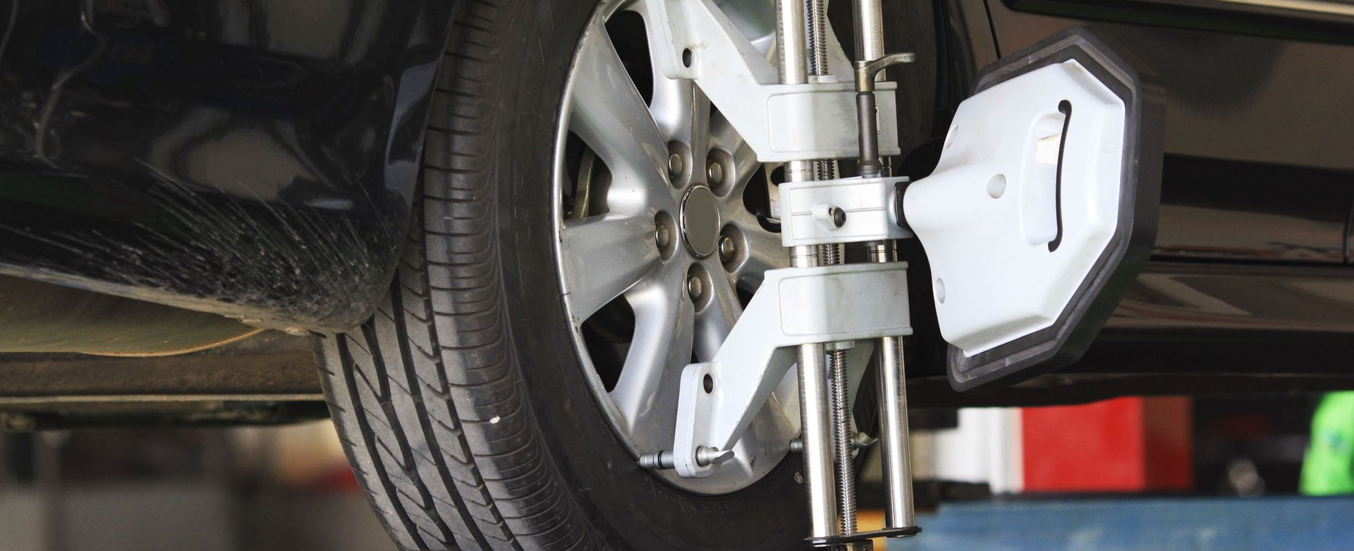 Car wheel being aligned with tools.
