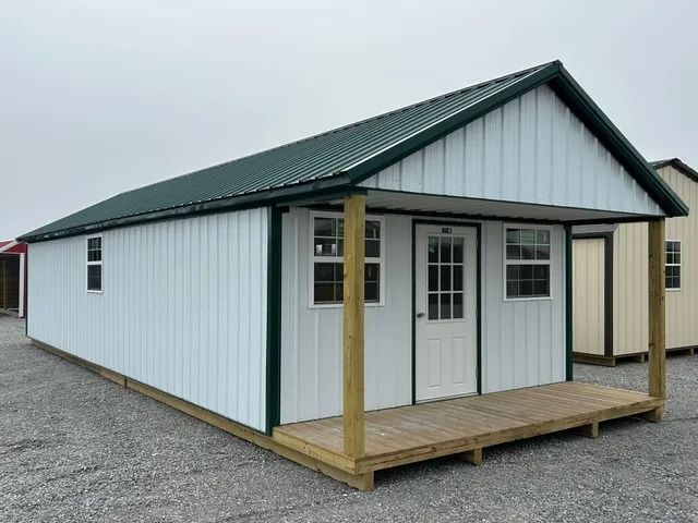 A white house with a green roof and a porch