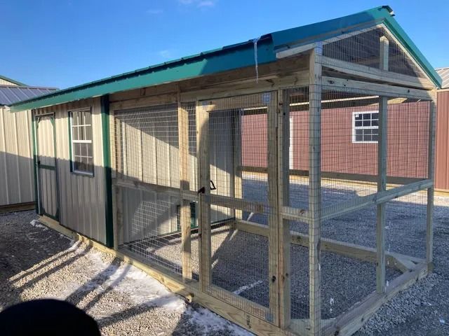 A wooden chicken coop with a green roof and a window.