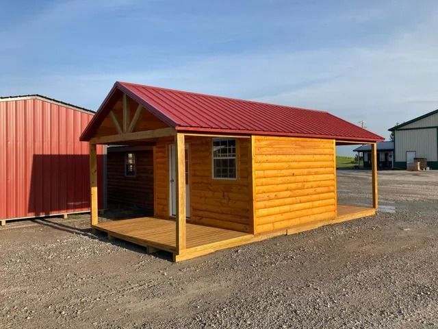 A small wooden cabin with a red roof and a porch.