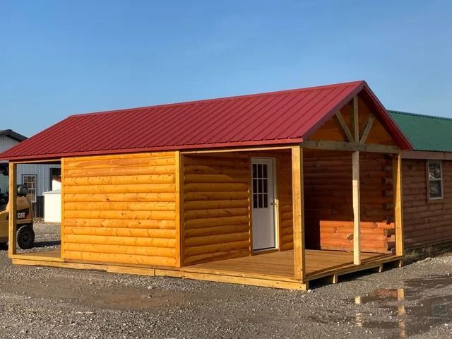 A log cabin with a red roof and a porch