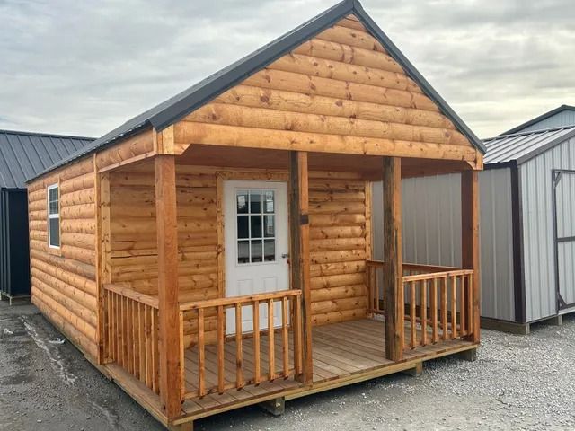 A small log cabin with a porch and a white door.