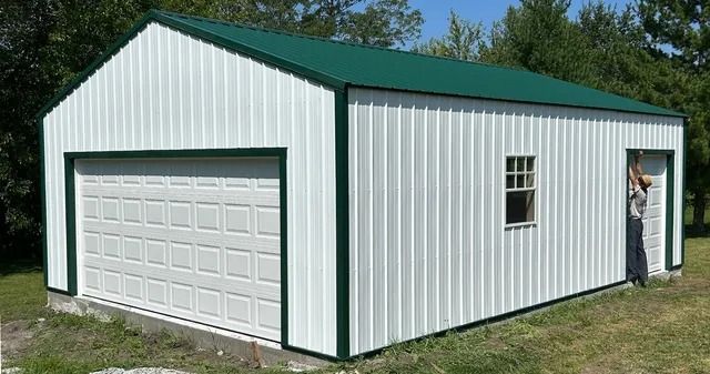 A white garage with a green roof and a window.