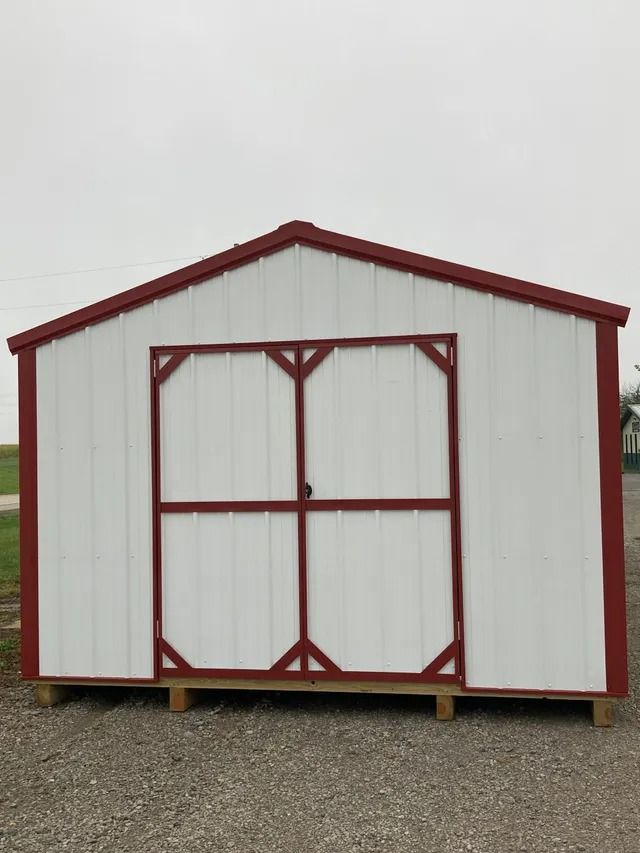 A white shed with a red roof and doors