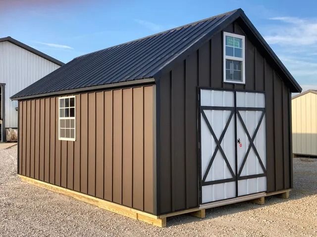 A brown shed with a black roof and white doors