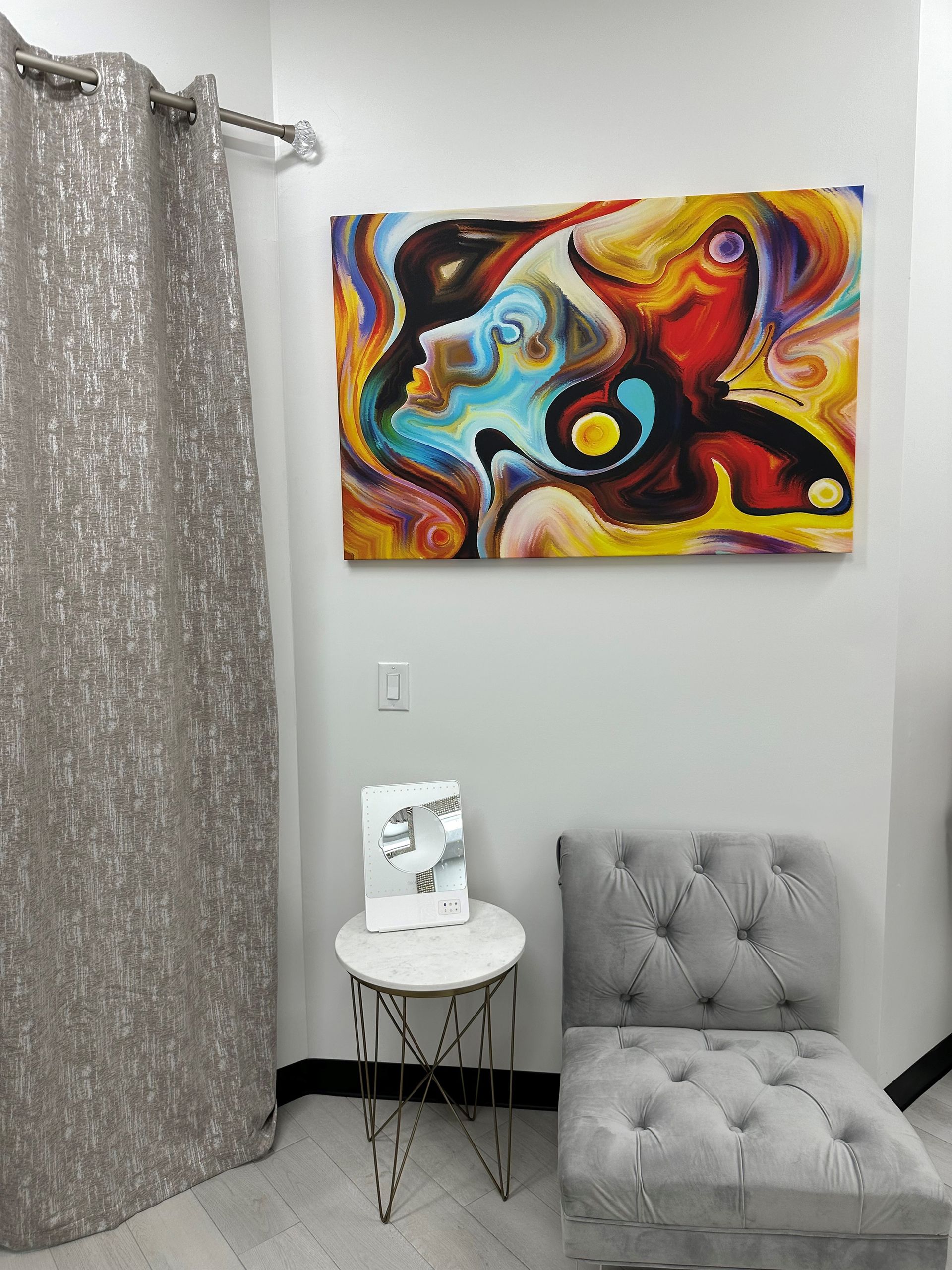 a room with a chair and a painting on the wall