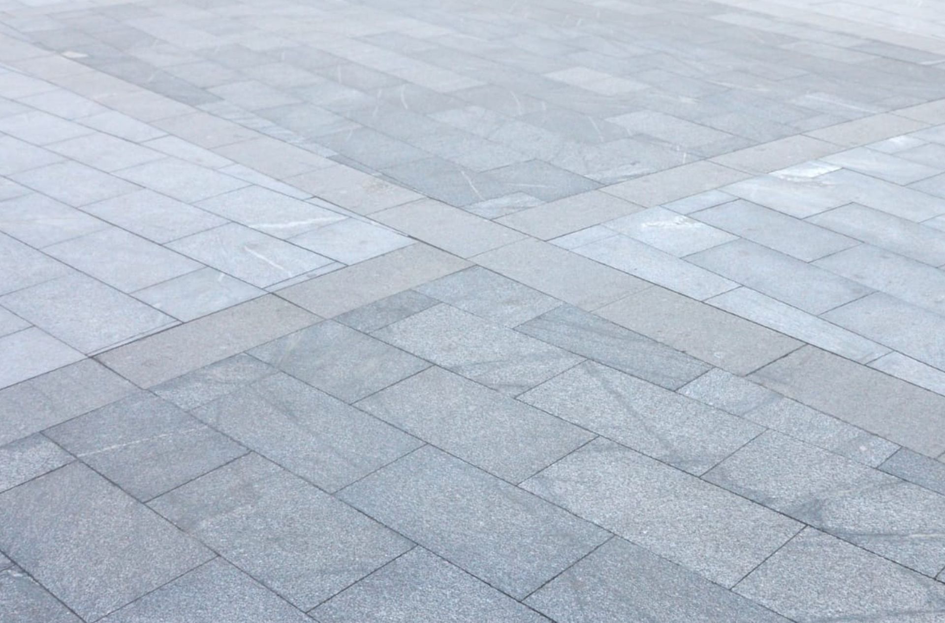 Gray stone paved walkway with darker gray cross pattern.