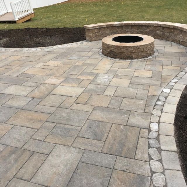 A patio with a fire pit in the middle of it