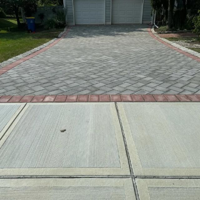 A brick driveway leading to a garage with a brick border