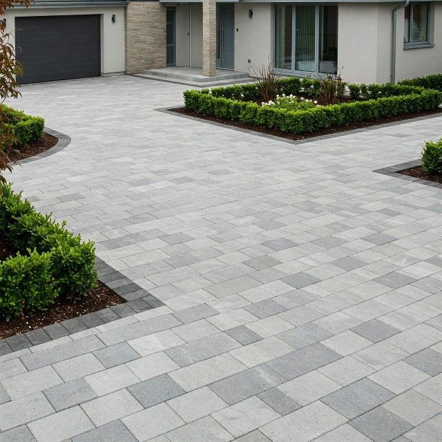 A driveway leading to a house with a black garage door