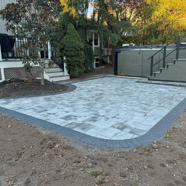 A patio with stairs and a hot tub in the background