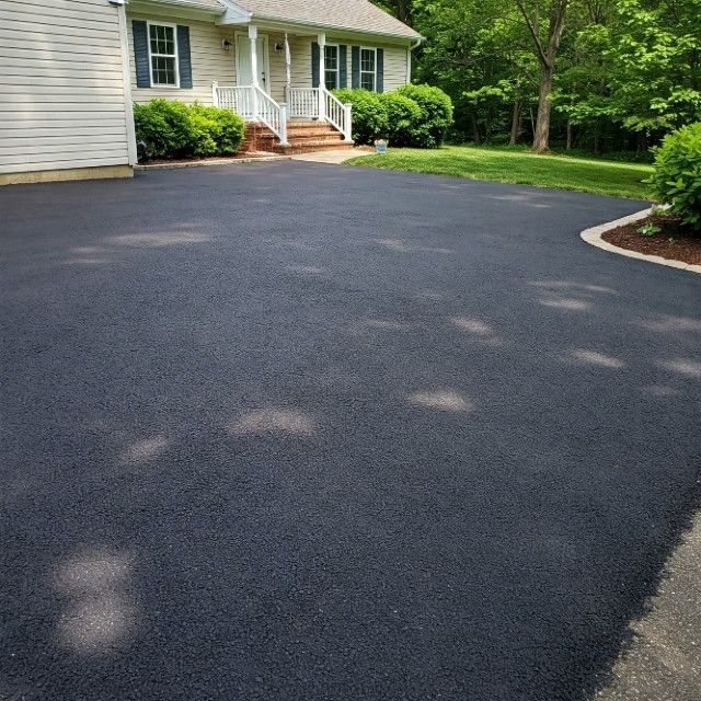 A house with a black driveway in front of it.