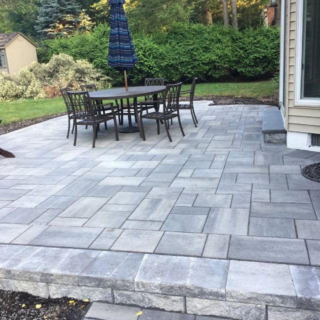 A patio with a table and chairs and an umbrella