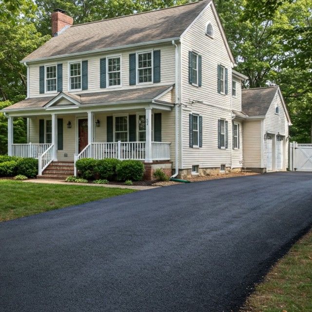 A large white house with a driveway leading to it