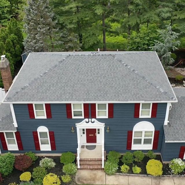 An aerial view of a blue house with red shutters