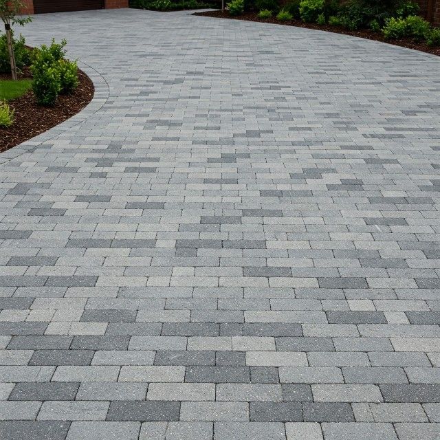 A brick driveway with a curved curve in the middle
