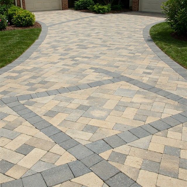 A brick driveway with a herringbone pattern