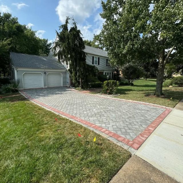A driveway leading to a house with two garage doors