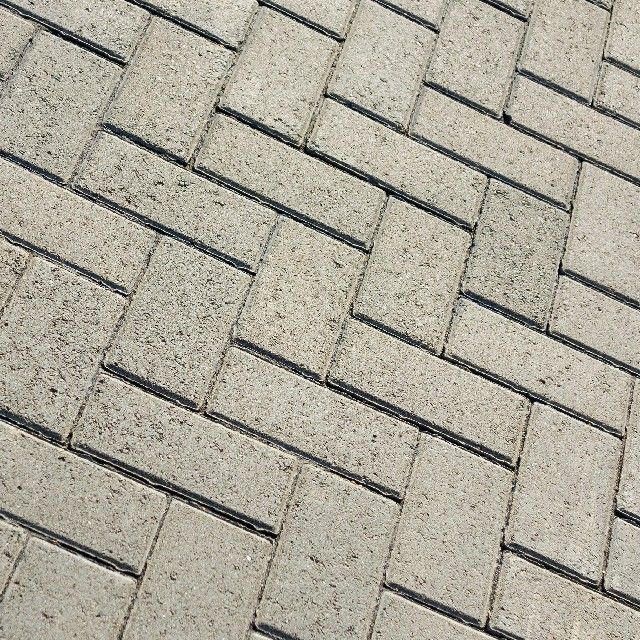 A close up of a brick pavement with a herringbone pattern