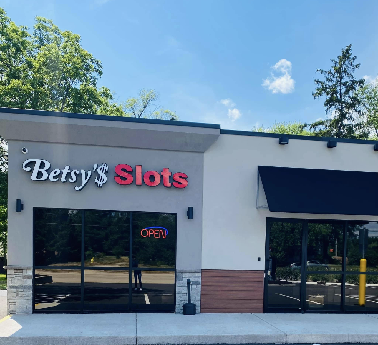 Gaming parlor storefront with large windows and a red and white sign against a blue sky.