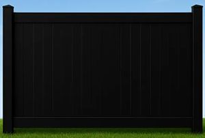 A section of black vinyl privacy fencing standing on a green grass lawn against a blue sky.