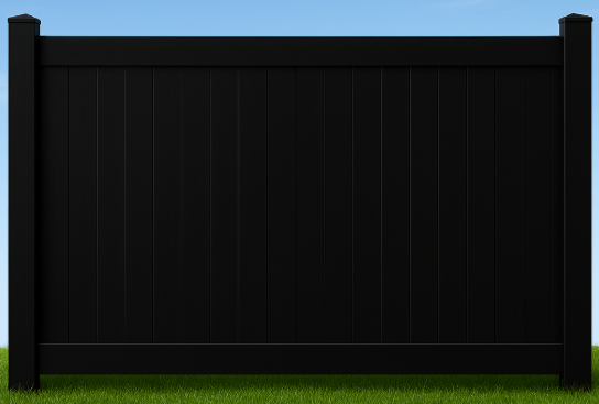 A section of black vinyl privacy fencing standing on a green grass lawn against a blue sky.