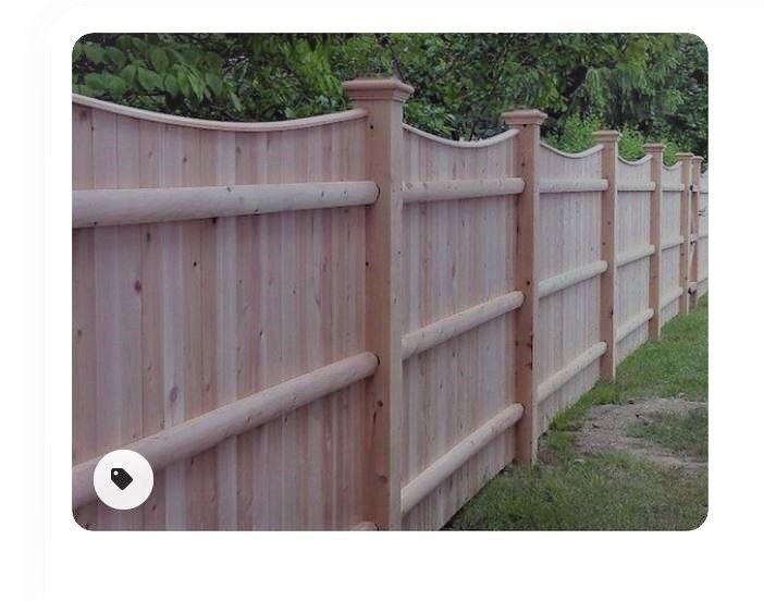 A wooden fence with arched top panels and two horizontal support rails between square posts on a lawn.