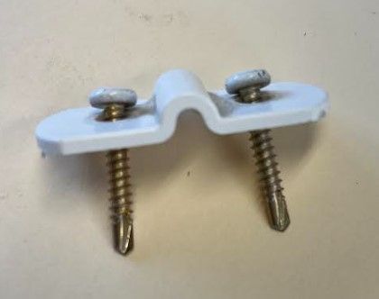 A white plastic bridge-style bracket with two metal self-drilling screws inserted, isolated against a plain background.