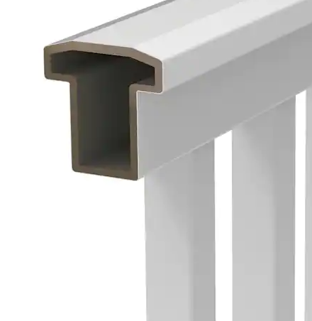 A close-up view of a white, T-shaped railing top, showing its hollow profile and connected vertical balusters.