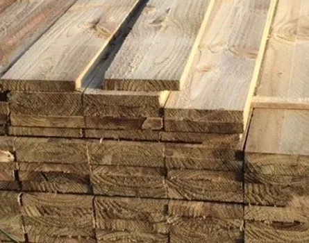 A stack of weathered, light brown wooden planks piled neatly in an outdoor setting.