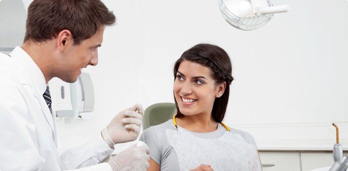 Dentist advising the patient to use dental floss
