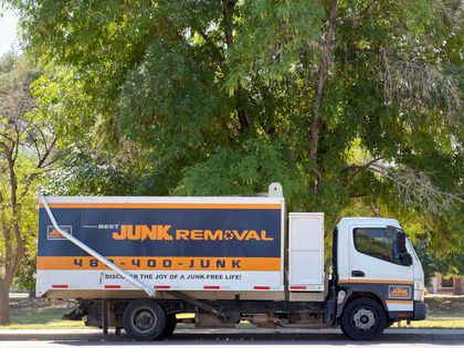 Two large recycling bins, blue and green, on pavement.