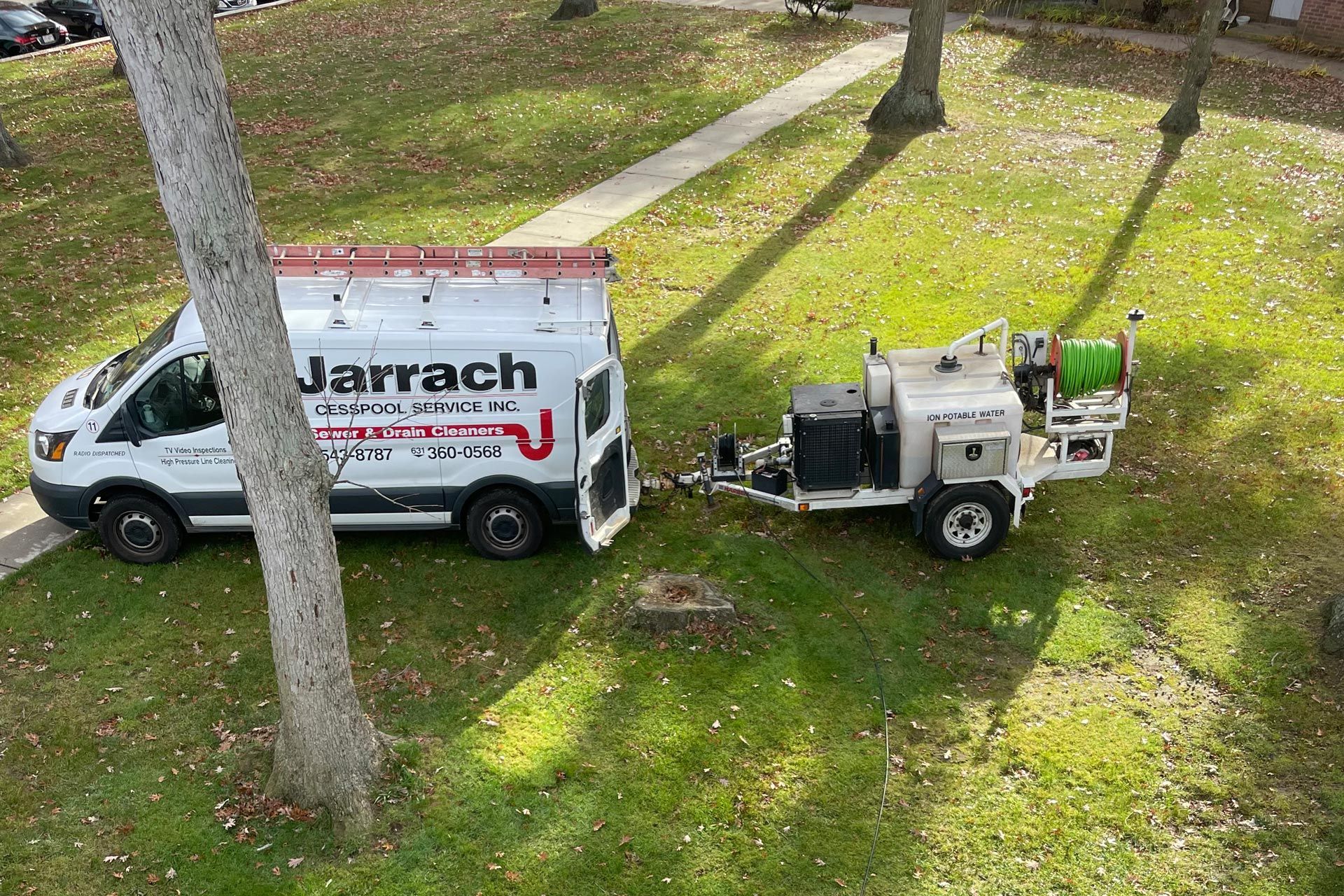 a white van with a trailer attached to it is parked in a grassy area