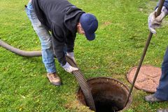 a man is pumping a manhole cover with a hose