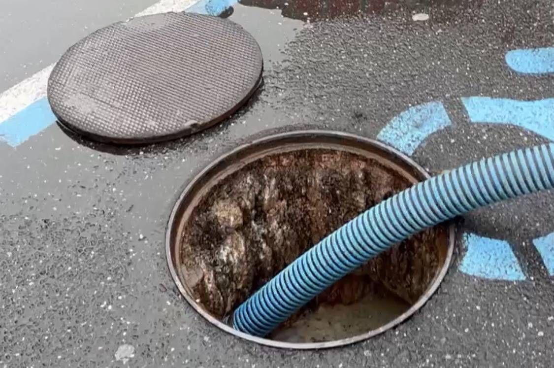 a manhole cover is sitting in the middle of a muddy area