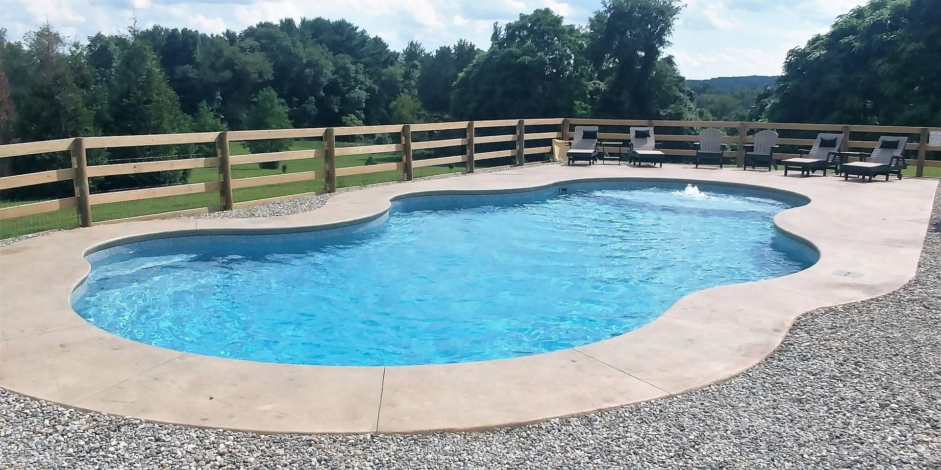A large swimming pool with a wooden fence around it
