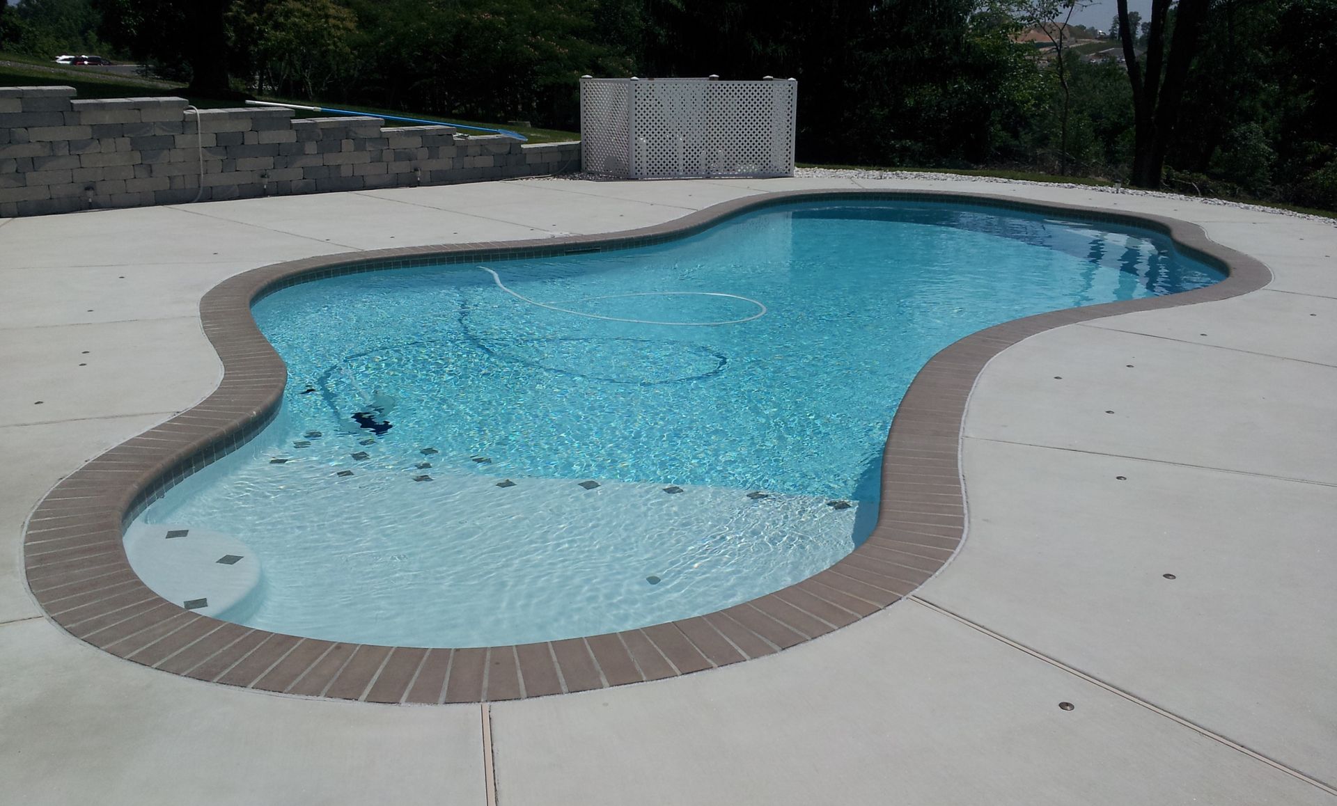 A large swimming pool is sitting on top of a concrete deck.