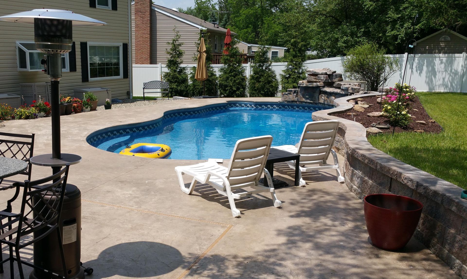 A large swimming pool is in the backyard of a house