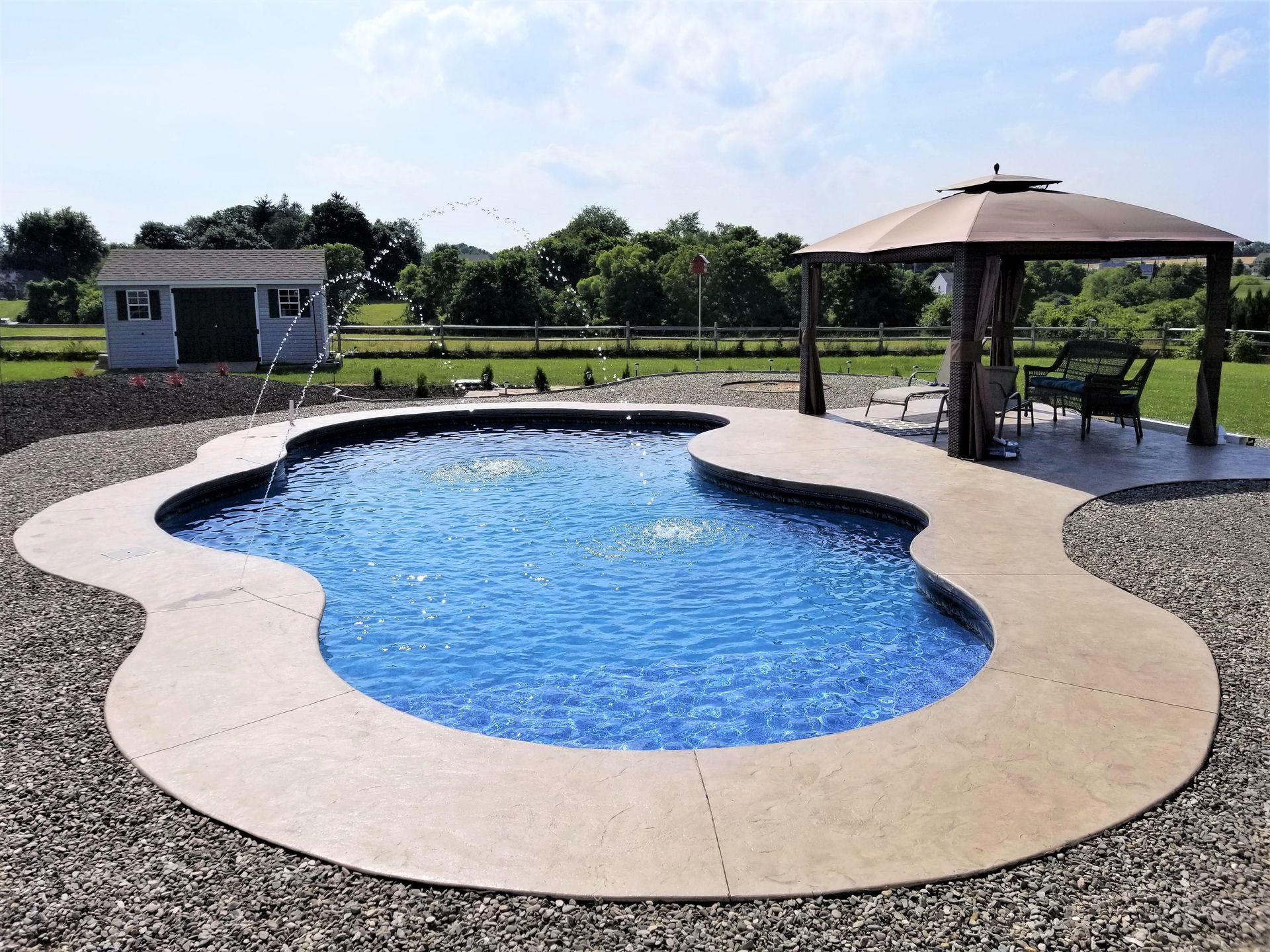 A large swimming pool with a gazebo in the background