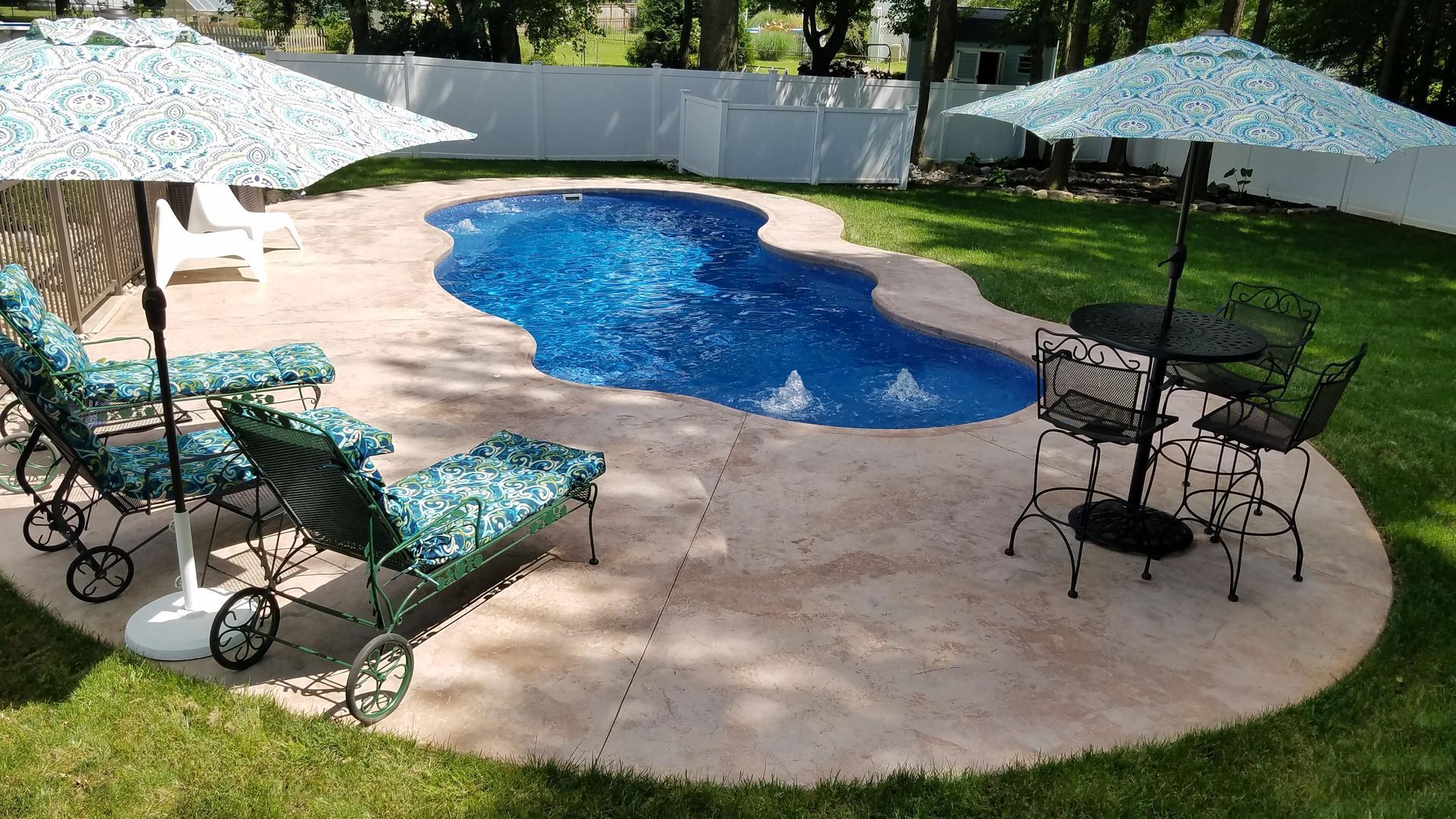 A swimming pool with chairs and umbrellas around it